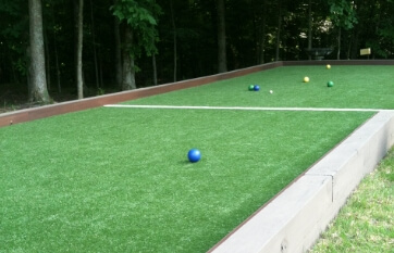 raised, wood-sided bocce court with synthetic turf surface