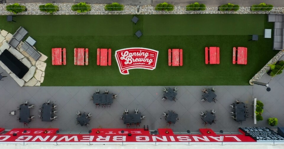 aerial view of Lansing Brewing Company patio with picnic tables and bocce courts for employees to enjoy