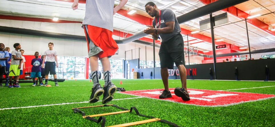 youth athletes working out on XGrass synthetic turf indoors at D1 sports facility