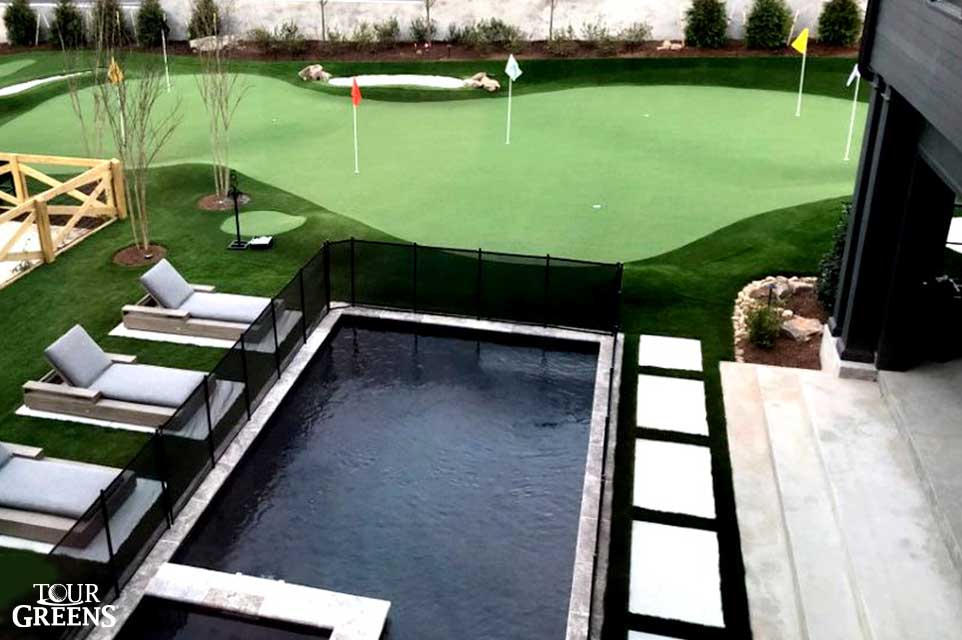 Tour Greens putting green doubling as a pool surround in the backyard