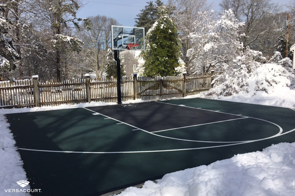 VersaCourt backyard basketball court during the winter