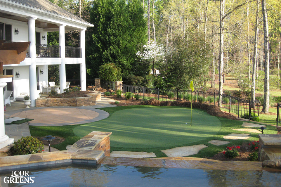Pool, patio, and putting green installed in a large backyard