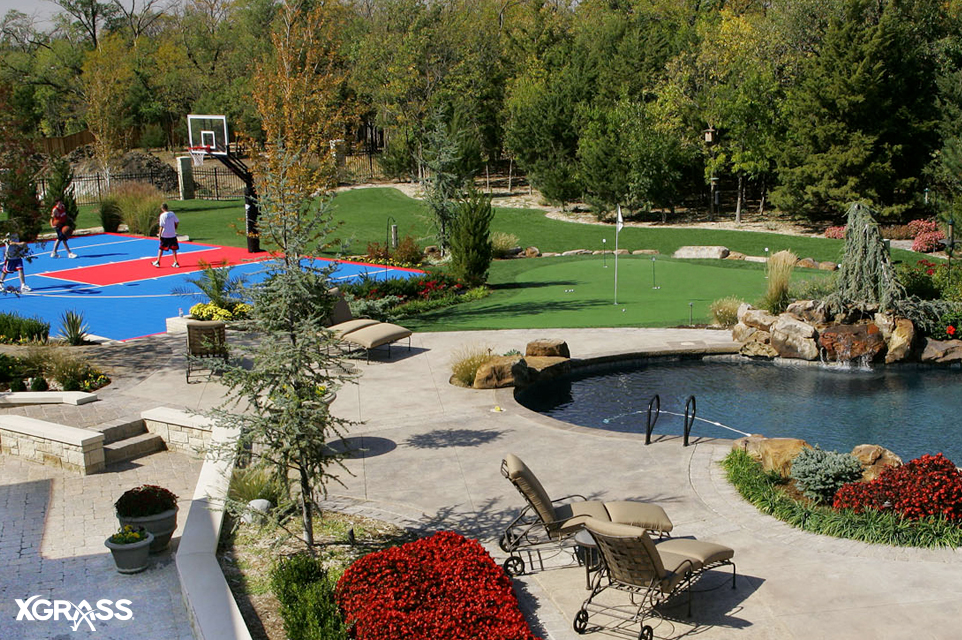 Elegant backyard with a basketball court from VersaCourt and a putting green from TourGreens