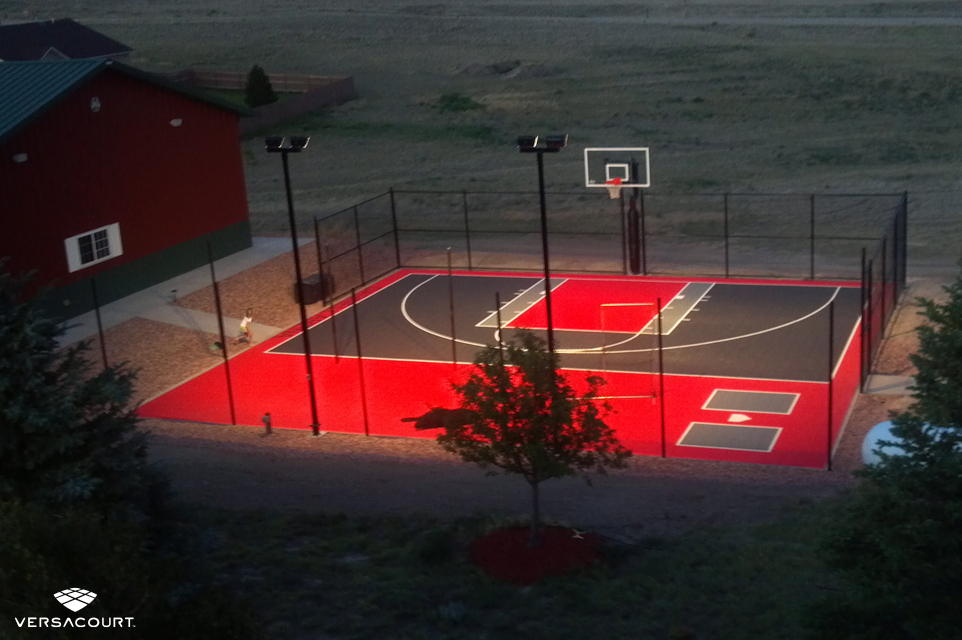Backyard basketball court with court lighting