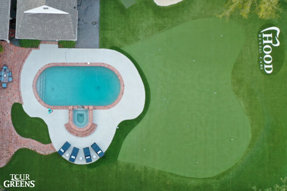 Large backyard swimming pool with a novelty putting green from Tour Greens installed