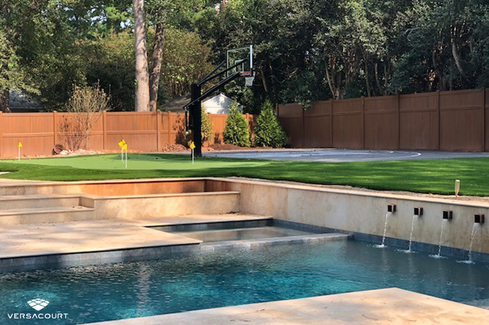 Backyard swimming pool with a putting green and basketball court next to it