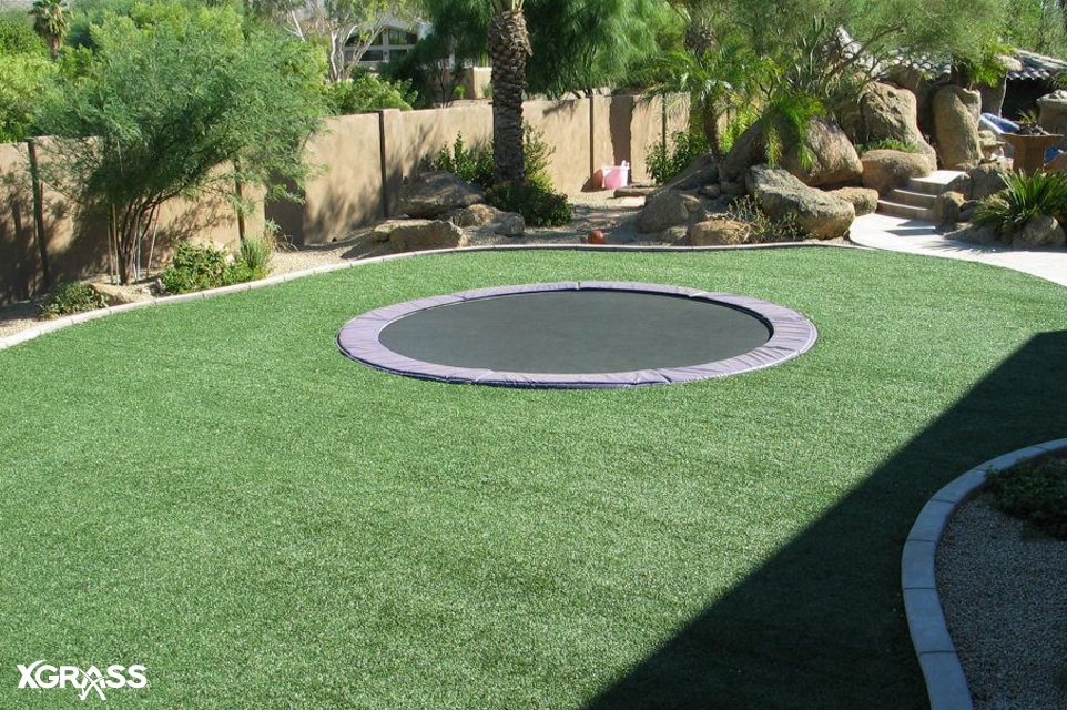 In-ground trampoline with XGrass artificial grass installed around it