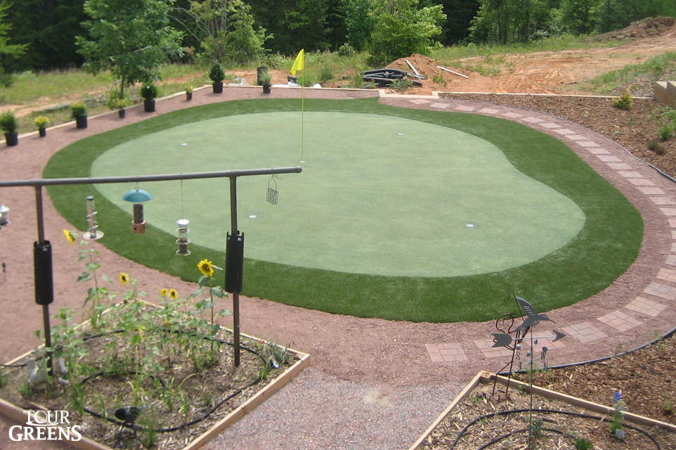 Backyard patio with a small putting green installed