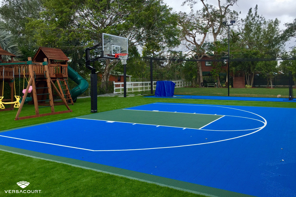 Backyard playground with VersaCourt's basketball court installed