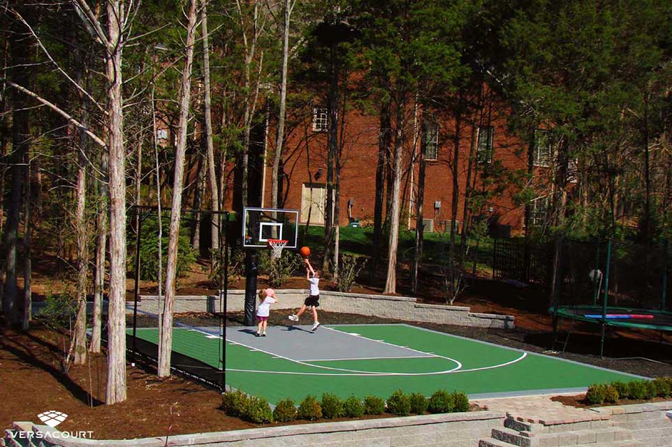 Kids playing in their backyard basketball court