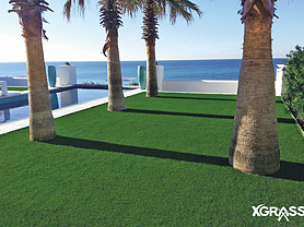Artificial grass with palm trees around pool