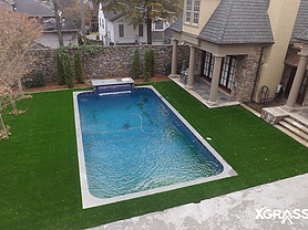 Top view of swimming pool surrounded by artificial turf