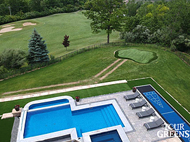 Tour Greens backyard putting green next to swimming pool